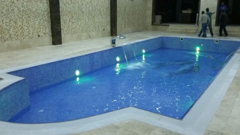 Mavi mozaik kaplamalı, su altı aydınlatmalı kapalı havuz